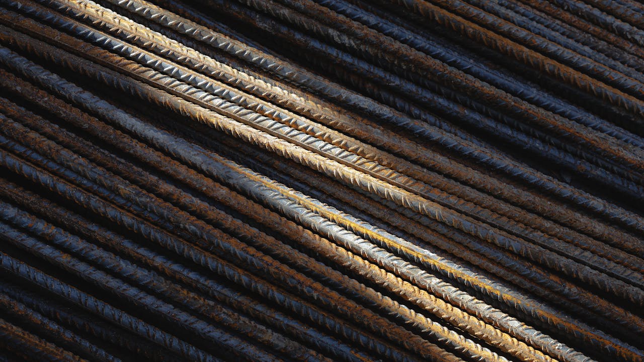 Detailed view of intersecting steel rebars showing texture and rust patterns under sunlight.