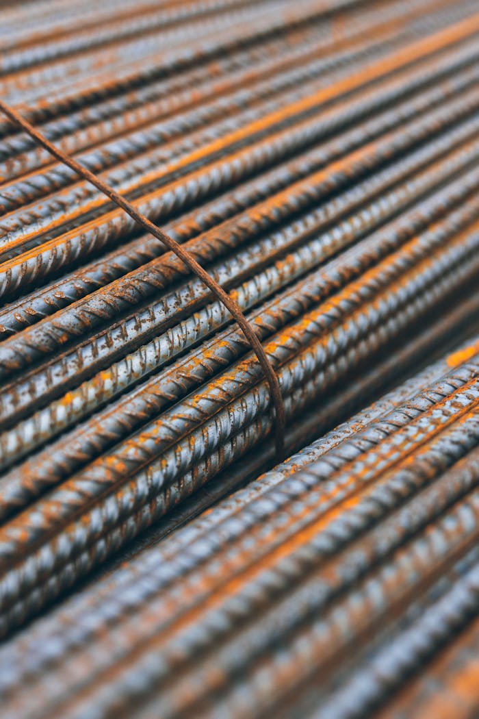 Detailed view of rusty steel rebars stacked in parallel pattern highlighting construction materials texture.